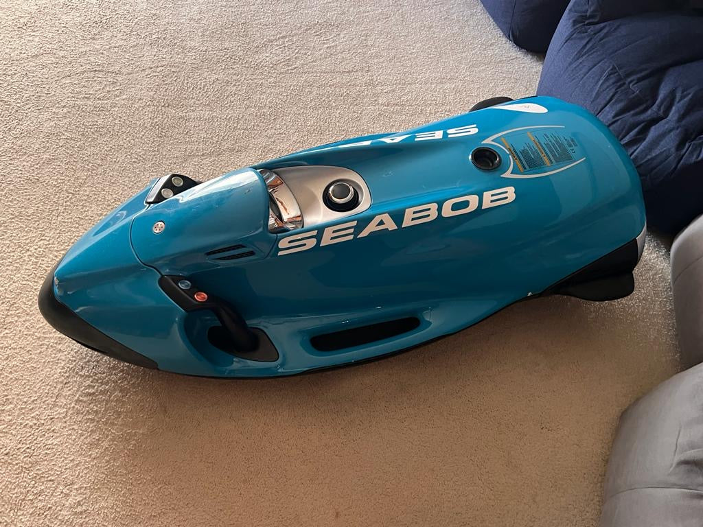 Blue Seabob water scooter on a carpeted floor